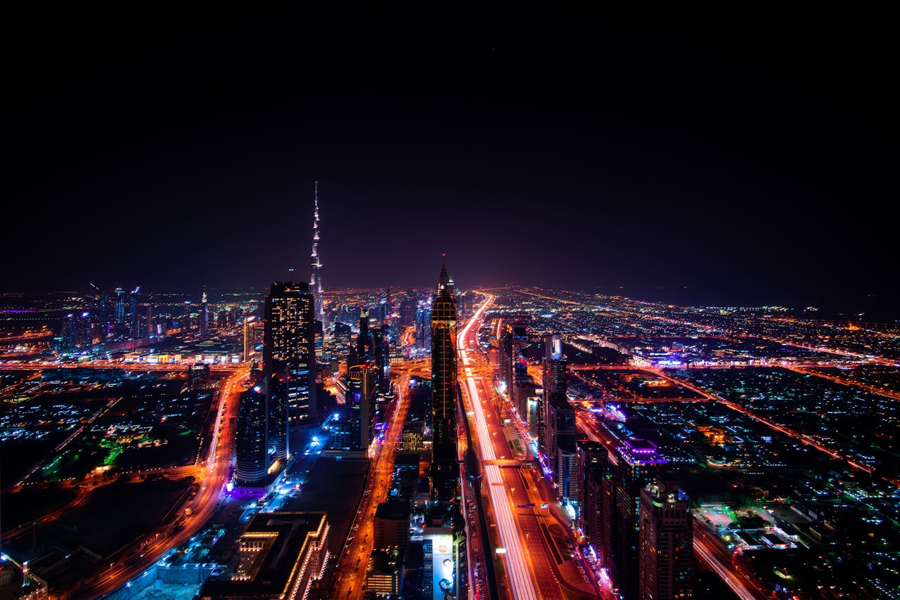 about-header A breathtaking aerial view of Dubais cityscape at night, highlighting the illuminated Burj Khalifa and surrounding skyscrapers.