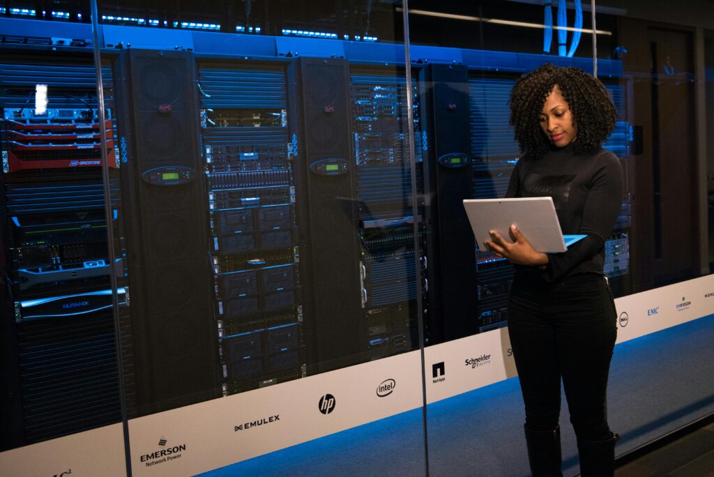 pexels photo 1181354 1181354 A female engineer using a laptop while monitoring data servers in a modern server room.