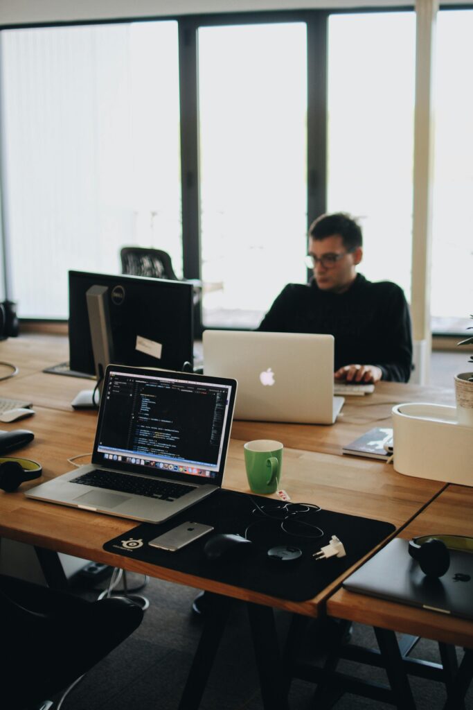 pexels photo 2102416 2102416 A web developer working on code in a modern office setting with multiple devices.