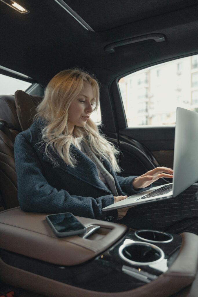 pexels photo 5717642 5717642 Businesswoman working remotely on a laptop in the backseat of a luxury car. Stylish, modern, and focused.